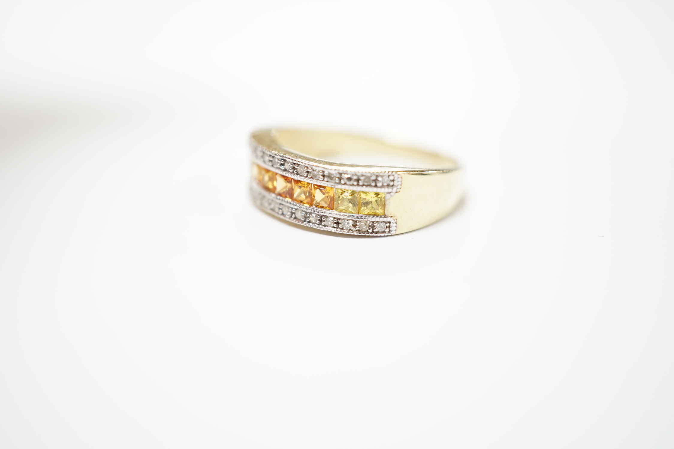 A modern 9ct gold, diamond, and two colour citrine? channel set half hoop ring, size P, gross weight 3.3 grams.